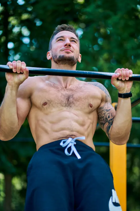 Patryk Wygadańczuk podciąga się na drążku w parku street workout