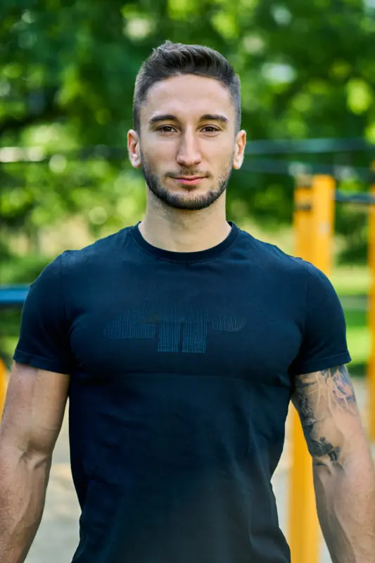 Patryk w czarnej koszulce na placu street workout